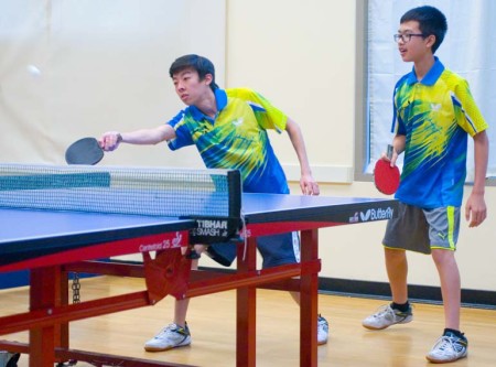 Christopher Chen stretches for a return shot while Three Tenor partner Jeffery Yee watches.